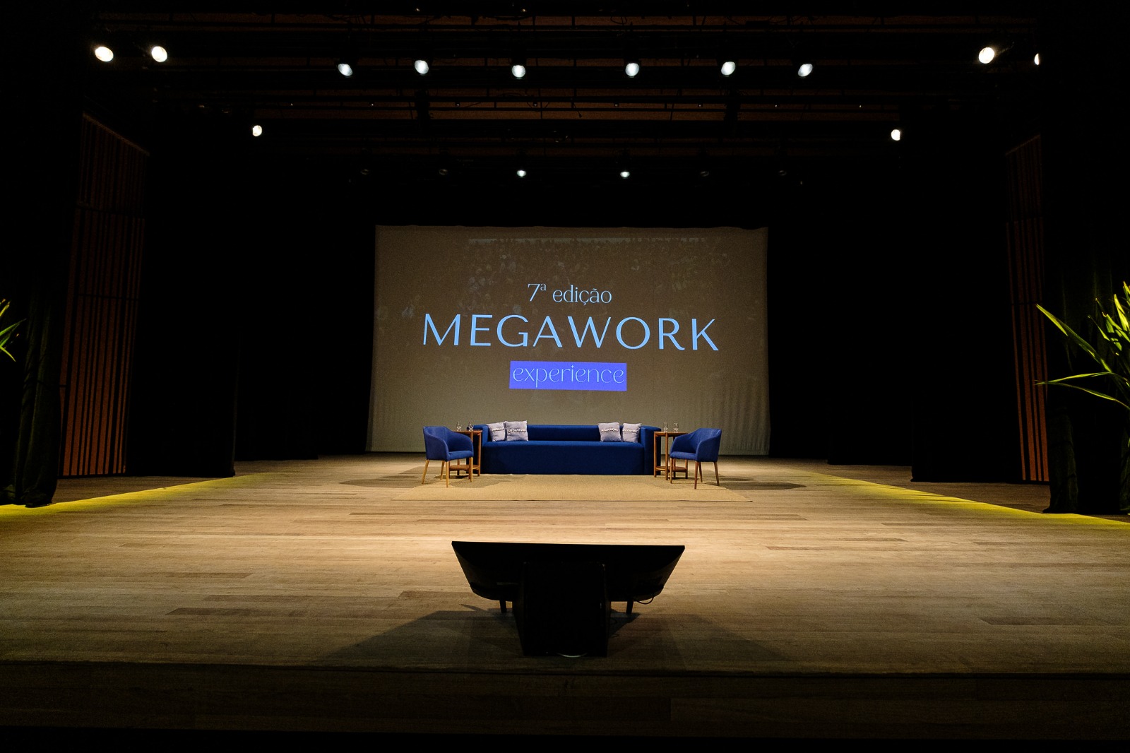 Palco do MegaWork Experience com painel da 7ª edição do evento